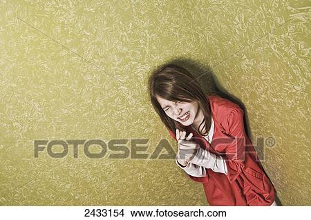 Picture - Young girl clutching her hand in anguish; Hartford, Connecticut, USA. Fotosearch