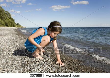Young Girl Collecting Stones On The Beach By Lake Ontario; Ontario Canada View Large Photo Image Stock Image - Young Girl Collecting Stones On The Beach By Lake Ontario; Ontario Canada. Fotosearch