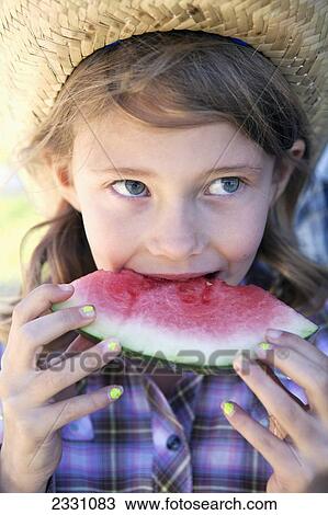 Stock Image - Young Girl Eating A Slice Of Watermelon; Langley British Columbia Canada. Fotosearch