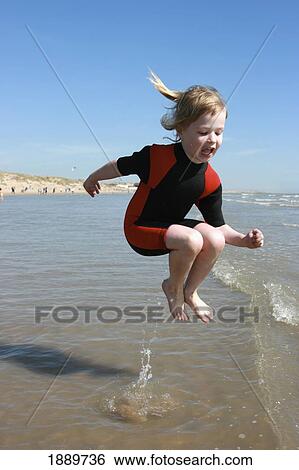 Young Girl In Wetsuit Jumping In Water View Large Photo Image Stock Photograph - Young Girl In Wetsuit Jumping In Water. Fotosearch