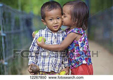 Young girl kissing a young boy; Battambang, Cambodia View Large Photo Image Stock Image - Young girl kissing a young boy; Battambang, Cambodia. Fotosearch