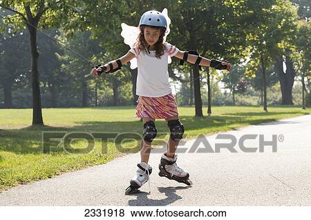 Stock Photo - Young Girl Learning To Inline Skate While Wearing Fairy Wings; Whitby Ontario Canada. Fotosearch