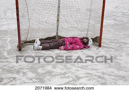 Picture - Young Girl Lying In A Hockey Net, Ontario. Fotosearch