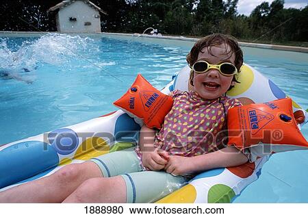 Stock Image - Young Girl On Inflatable Lilo In Pool. Fotosearch