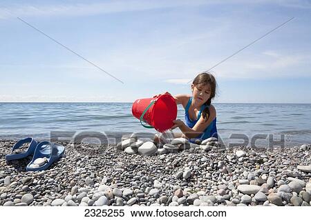 Young girl playing on a pebble beach on the shore of lake ontario; Ontario canada View Large Photo Image Stock Photography - Young girl playing on a pebble beach on the shore of lake ontario; Ontario canada. Fotosearch