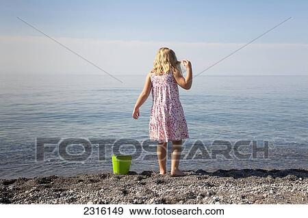 Stock Photo - Young Girl Playing On The Beach By Lake Ontario; Ontario Canada. Fotosearch
