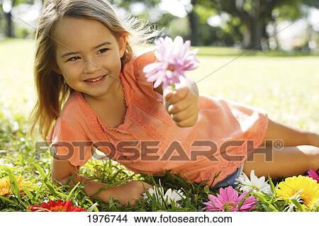 Young Girl Playing With Flowers In The Grass. View Large Photo Image Picture - Young Girl Playing With Flowers In The Grass.. Fotosearch