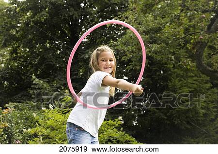 Young Girl Playing With Her Hula Hoop In The Garden; Ontario Canada View Large Photo Image Stock Photo - Young Girl Playing With Her Hula Hoop In The Garden; Ontario Canada. Fotosearch
