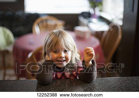 Young girl sitting at the kitchen counter; Surrey, British Columbia, Canada View Large Photo Image Stock Photo - Young girl sitting at the kitchen counter; Surrey, British Columbia, Canada. Fotosearch