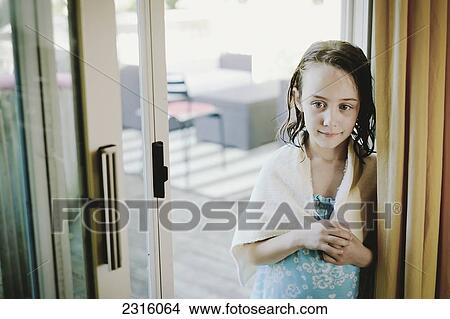 Picture - Young Girl Standing In Patio Door With Wet Hair And A Towel; Otterburn Park Quebec Canada. Fotosearch