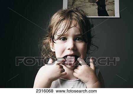 Stock Photo - Young Girl Sticking Her Tongue Out At Camera; Otterburn Park Quebec Canada. Fotosearch