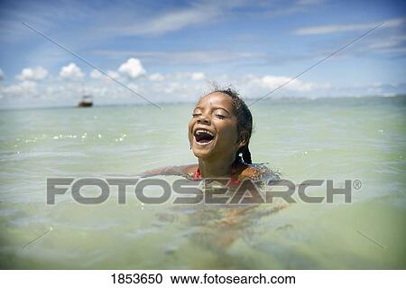 Stock Image - Young Girl Swimming In Ocean, Brazil. Fotosearch