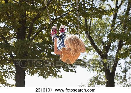 Young Girl Swinging High In The Air; Ontario Canada View Large Photo Image Stock Photo - Young Girl Swinging High In The Air; Ontario Canada. Fotosearch