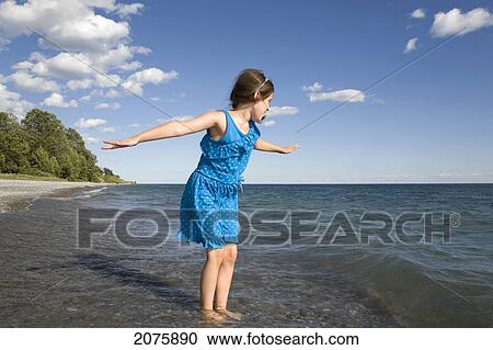 Young Girl Waiting For The Wave To Break On The Shoreline Of Lake Ontario; Ontario Canada View Large Photo Image Stock Image - Young Girl Waiting For The Wave To Break On The Shoreline Of Lake Ontario; Ontario Canada. Fotosearch