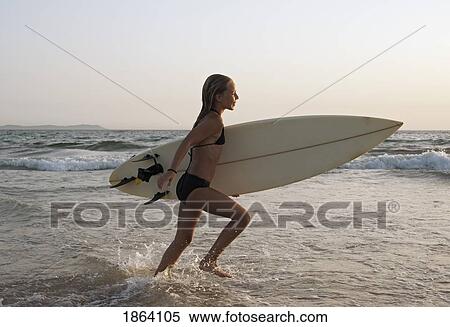 Stock Photography - Young Girl With Surfboard; Costa De La Luz, Andalusia, Spain. Fotosearch