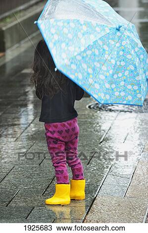 Stock Image - Young Girl With Umbrella In The Rain; Tokyo, Japan. Fotosearch