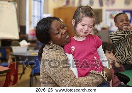 Young Grade 2 Student Being Comforted By Teacher; Toronto Ontario Canada View Large Photo Image Stock Photograph - Young Grade 2 Student Being Comforted By Teacher; Toronto Ontario Canada. Fotosearch