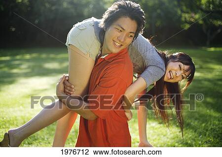 Stock Image - Young Japanese Couple Playing Together.. Fotosearch