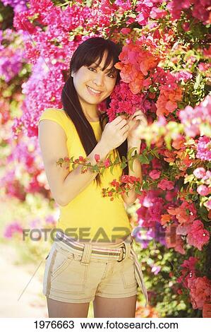 Young Japanese Girl Posing With Bright Pink Flowers. View Large Photo Image Stock Image - Young Japanese Girl Posing With Bright Pink Flowers.. Fotosearch