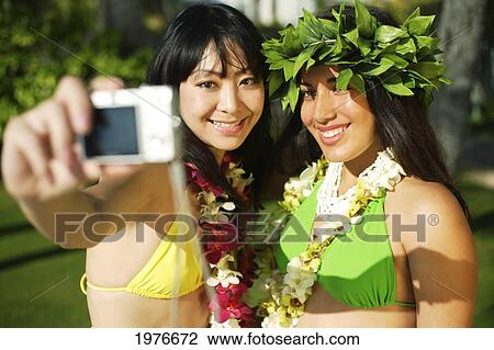 Stock Image - Young Japanese Girl Snapping Photograph With Hula Teacher.. Fotosearch
