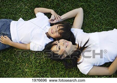 Young Japanese Mother And Child Posing In The Grass. View Large Photo Image Stock Photograph - Young Japanese Mother And Child Posing In The Grass.. Fotosearch