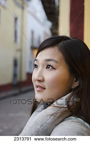 Stock Image - Young Korean woman with old Spanish buildings in background; Guanajuato, Guanajuato State, Mexico. Fotosearch