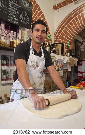 Young male baker rolling out pizza dough; Guanajuato, Guanajuato State, Mexico View Large Photo Image Stock Image - Young male baker rolling out pizza dough; Guanajuato, Guanajuato State, Mexico. Fotosearch