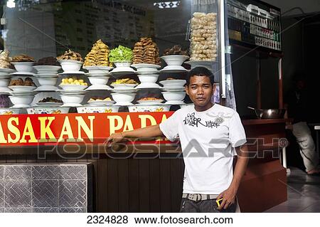 Stock Photo - Young Man In Front Of Padang Food Display, Kuta, Bali, Indonesia. Fotosearch