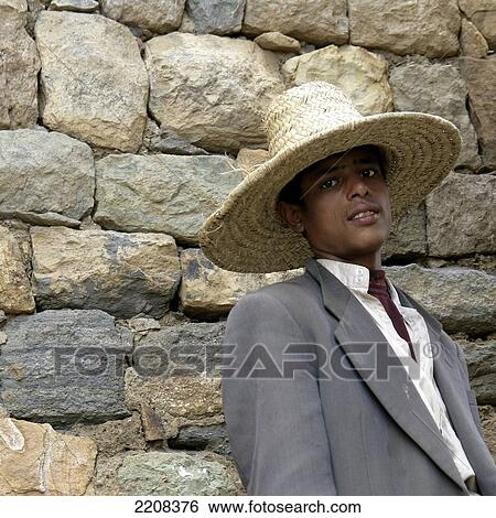 Stock Photograph - Young Man In Straw Hat In Mountain Top Village. Yemen.. Fotosearch