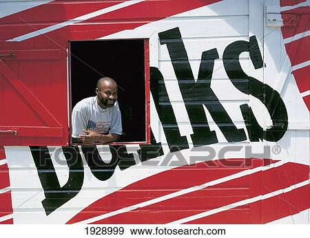 Stock Photo - Young Man In Window Of Banks Bar; Barbados. Fotosearch