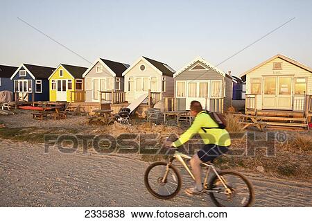 Young Man Riding Mountain Bicycle On Beach Near Beach Huts; Christchurch Harbour, Mudeford, Dorset, England, United Kingdom View Large Photo Image Stock Photo - Young Man Riding Mountain Bicycle On Beach Near Beach Huts; Christchurch Harbour, Mudeford, Dorset, England, United Kingdom. Fotosearch