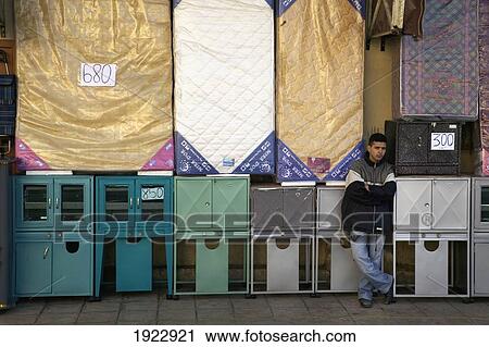 Stock Image - Young Man Selling Kitchen And Bedroom Items In Mellah, The Jewish Neighborhood, Fes, Morocco. Fotosearch