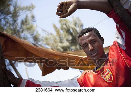 Young man wearing Arsenal football shirt; Ethiopia View Large Photo Image Picture - Young man wearing Arsenal football shirt; Ethiopia. Fotosearch