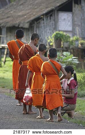 Young monks collecting alms in Tat Lo village; Champasak Province, Laos View Large Photo Image Stock Photo - Young monks collecting alms in Tat Lo village; Champasak Province, Laos. Fotosearch