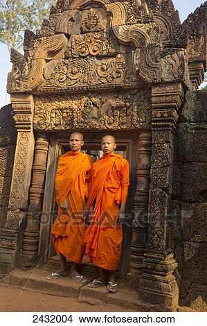 Picture - Young monks visiting 10th Century Banteay Srei temple; Siem Reap Province, Cambodia. Fotosearch