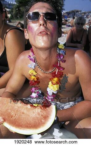 Stock Photo - Young People On The Beach Eating Watermelon. Fotosearch