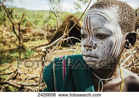 Young Suri (Surma) tribe cattle herder with painted face, Omo region, Southwest Ethiopia; Kibish, Ethiopia View Large Photo Image Stock Photo - Young Suri (Surma) tribe cattle herder with painted face, Omo region, Southwest Ethiopia; Kibish, Ethiopia. Fotosearch