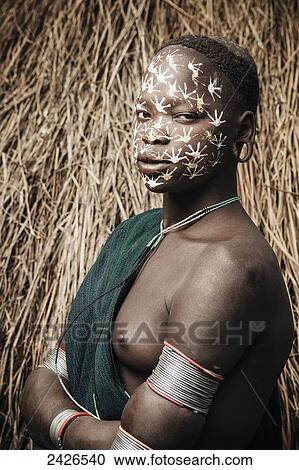 Stock Image - Young Surma (Suri) woman with traditional face decoration, Southwest Ethiopia; Kibish, Ethiopia. Fotosearch