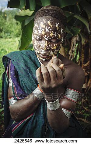 Stock Photograph - Young Surma (Suri) woman with traditional face decoration, Southwest Ethiopia; Kibish, Ethiopia. Fotosearch