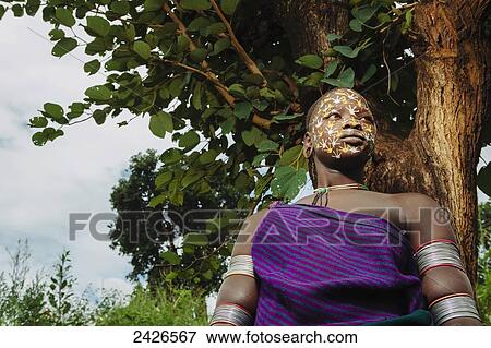 Young Surma woman with traditionally painted face, Omo region, Southwest Ethiopia; Kibish, Ethiopia View Large Photo Image Stock Photo - Young Surma woman with traditionally painted face, Omo region, Southwest Ethiopia; Kibish, Ethiopia. Fotosearch