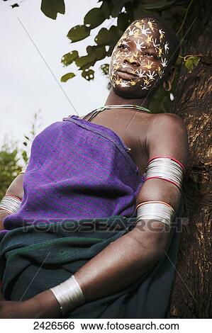 Stock Photograph - Young Surma woman with traditionally painted face, Omo region, Southwest Ethiopia; Kibish, Ethiopia. Fotosearch