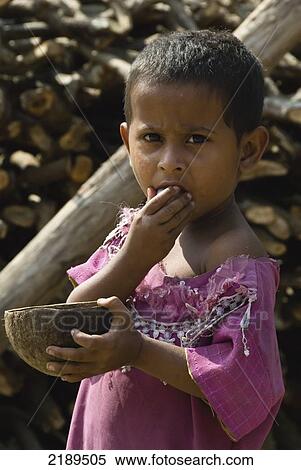 Stock Photography - Young Tribal Girl Eating Rice From A Coconut Bowl, Raghurajpur, Orissa, India. Fotosearch