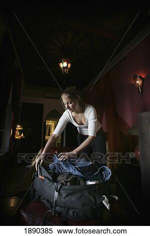 Stock Photography - Young Woman Backpacker Packing Her Backpack In Riad (Ryad).. Fotosearch
