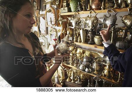 Young Woman Bargaining For A Silver Teapot In A Market Stall In The Souk. View Large Photo Image Stock Photography - Young Woman Bargaining For A Silver Teapot In A Market Stall In The Souk.. Fotosearch