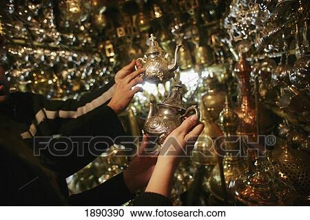 Young Woman Browsing For Silver Teapots And Metal Antiques In A Market Stall In The Souk. View Large Photo Image Stock Image - Young Woman Browsing For Silver Teapots And Metal Antiques In A Market Stall In The Souk.. Fotosearch