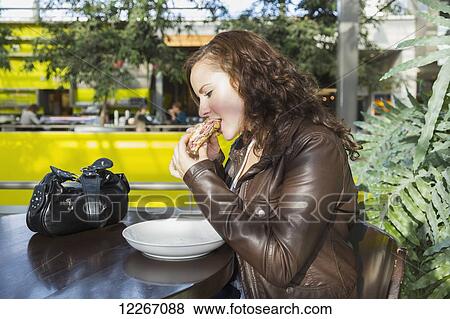 Stock Photo - Young woman having lunch at a cafe in the mall; St. Albert, Alberta, Canada. Fotosearch