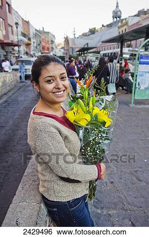Young woman holding a bouquet of flowers in the street; Guanajuato, Mexico View Large Photo Image Stock Photograph - Young woman holding a bouquet of flowers in the street; Guanajuato, Mexico. Fotosearch