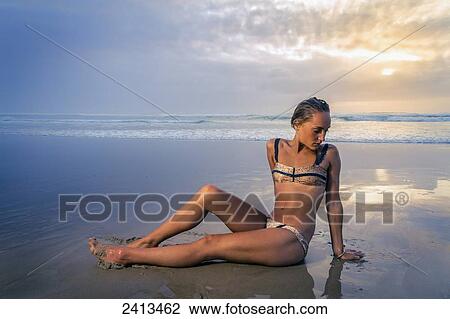 Young woman in a bikini on Tallows Beach at sunrise; New South Wales, Australia View Large Photo Image Stock Image - Young woman in a bikini on Tallows Beach at sunrise; New South Wales, Australia. Fotosearch