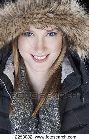 Stock Image - Young woman in a fur trimmed hood and winter coat; Edmonton, Alberta, Canada. Fotosearch