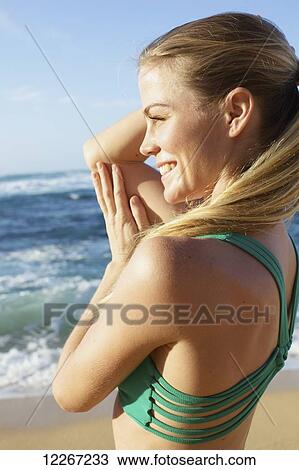 Young woman in fitness attire standing on the beach at water's edge; Kauai, Hawaii, United States of America View Large Photo Image Stock Image - Young woman in fitness attire standing on the beach at water's edge; Kauai, Hawaii, United States of America. Fotosearch